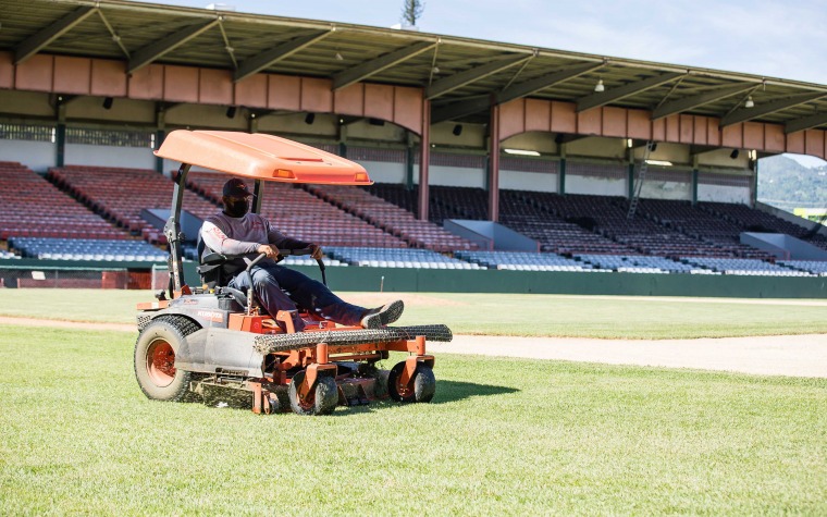 Cortacésped manual eléctrico en el estadio cuidado del césped en el campo  deportivo